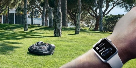 Robot tondeuse autonome géré via une montre connectée dans un grand jardin