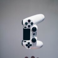 Manette de jeu blanche flottant au-dessus d'une main