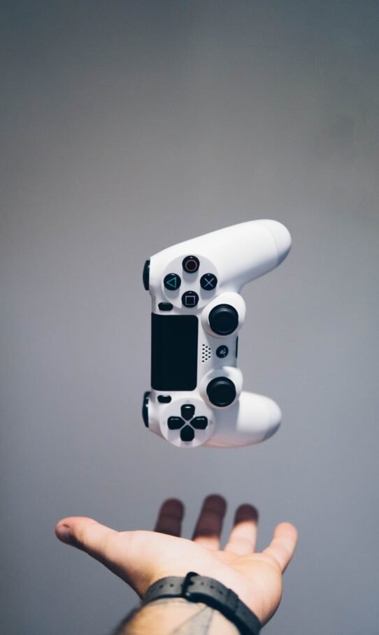 Manette de jeu blanche flottant au-dessus d'une main