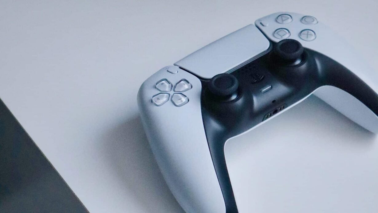 Manette de jeu noire et blanche posée sur un bureau blanc