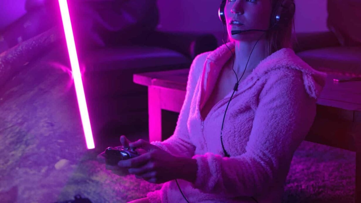 Personne jouant à un jeu vidéo sous une lumière néon violette