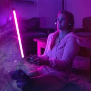 Personne jouant à un jeu vidéo sous une lumière néon violette