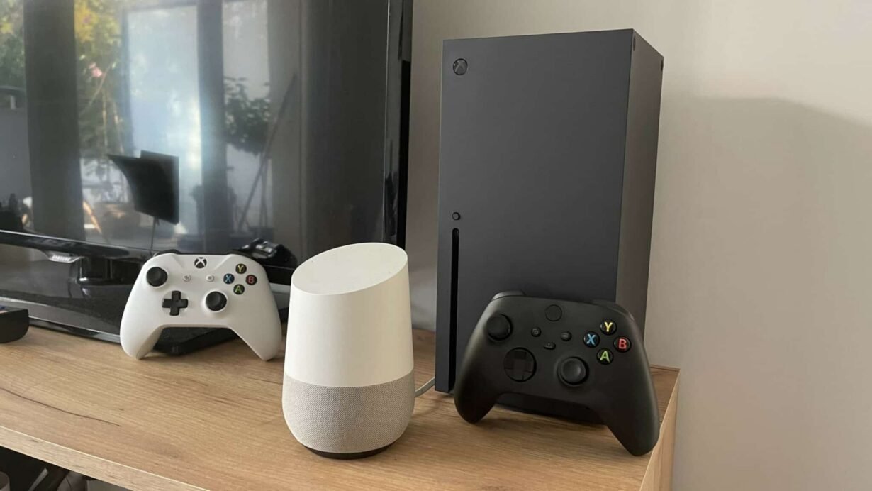 Console de jeu avec manettes et enceinte connectée sur une étagère