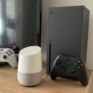 Console de jeu avec manettes et enceinte connectée sur une étagère