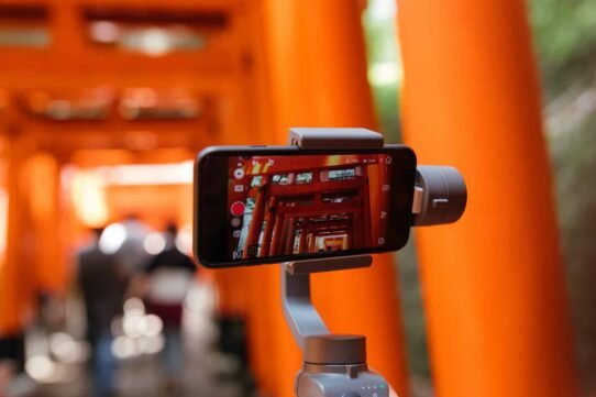 Smartphone filmant des torii rouges au Japon
