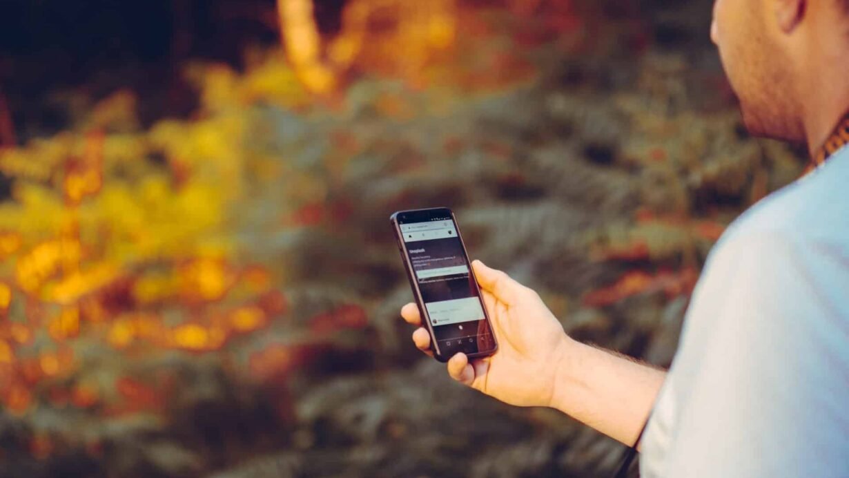 Homme regardant son smartphone dans un cadre naturel