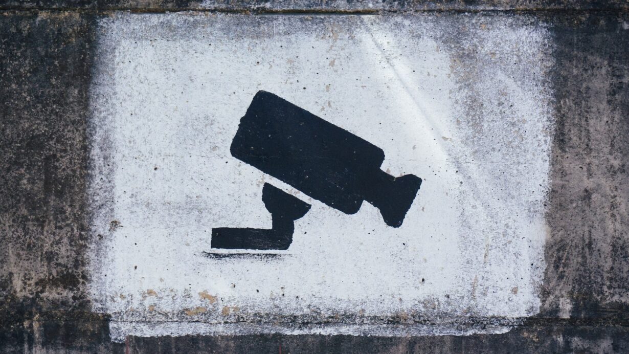 Silhouette d'une caméra de surveillance peinte sur un mur
