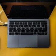 Ordinateur portable connecté à un disque dur externe sur une table jaune