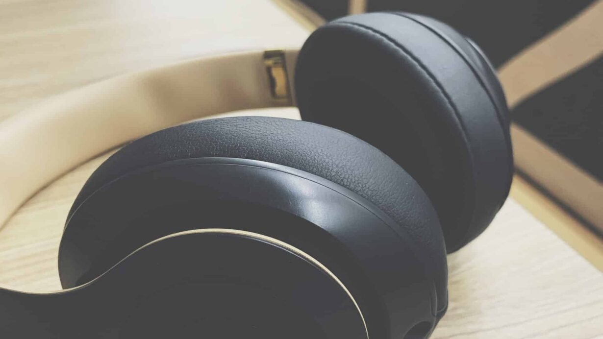 Casque audio noir et doré sur une table en bois clair