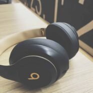 Casque audio noir et doré sur une table en bois clair