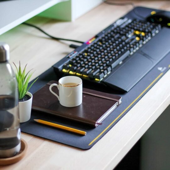 Bureau avec clavier, carnet, tasse et plante