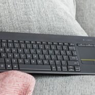 Clavier sans fil noir avec pavé tactile sur un canapé gris
