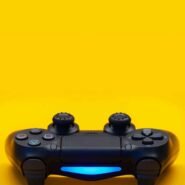 Manette de jeu noire avec lumière bleue sur fond jaune