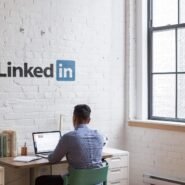 Homme travaillant sur un ordinateur portable dans un bureau avec logo LinkedIn
