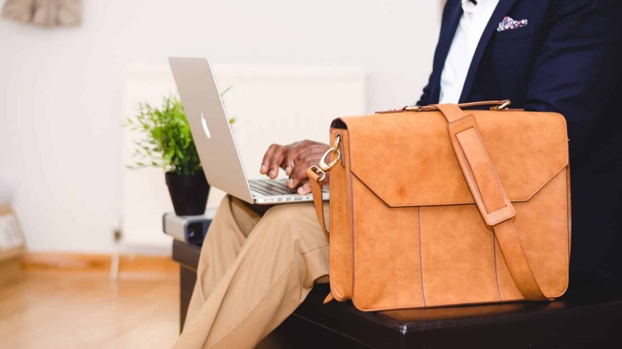Homme travaillant sur un ordinateur portable avec un sac en cuir