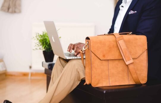 Homme travaillant sur un ordinateur portable avec un sac en cuir