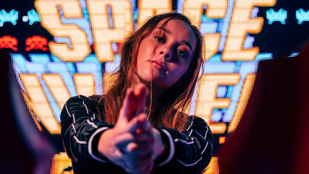 Femme posant devant un écran coloré avec le mot SPACE