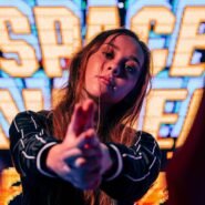 Femme posant devant un écran coloré avec le mot SPACE