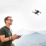 Homme contrôlant un drone dans un paysage de montagne