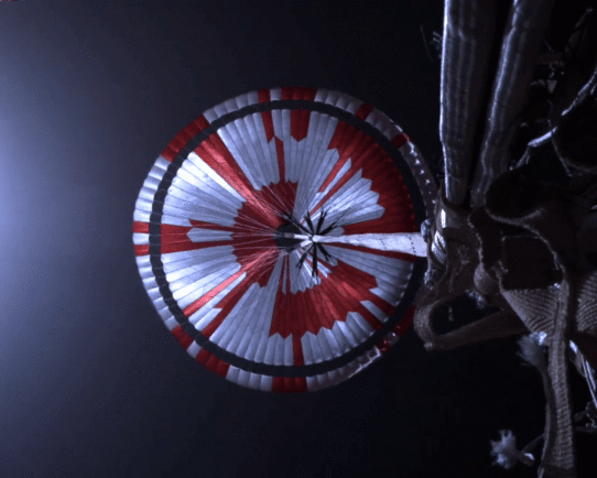 Parachute rouge et blanc se déployant dans l'espace