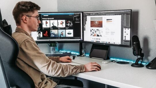 Personne travaillant sur un ordinateur avec deux écrans dans un bureau moderne