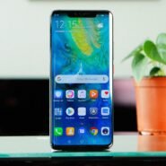 Smartphone moderne posé sur une table près d'une plante