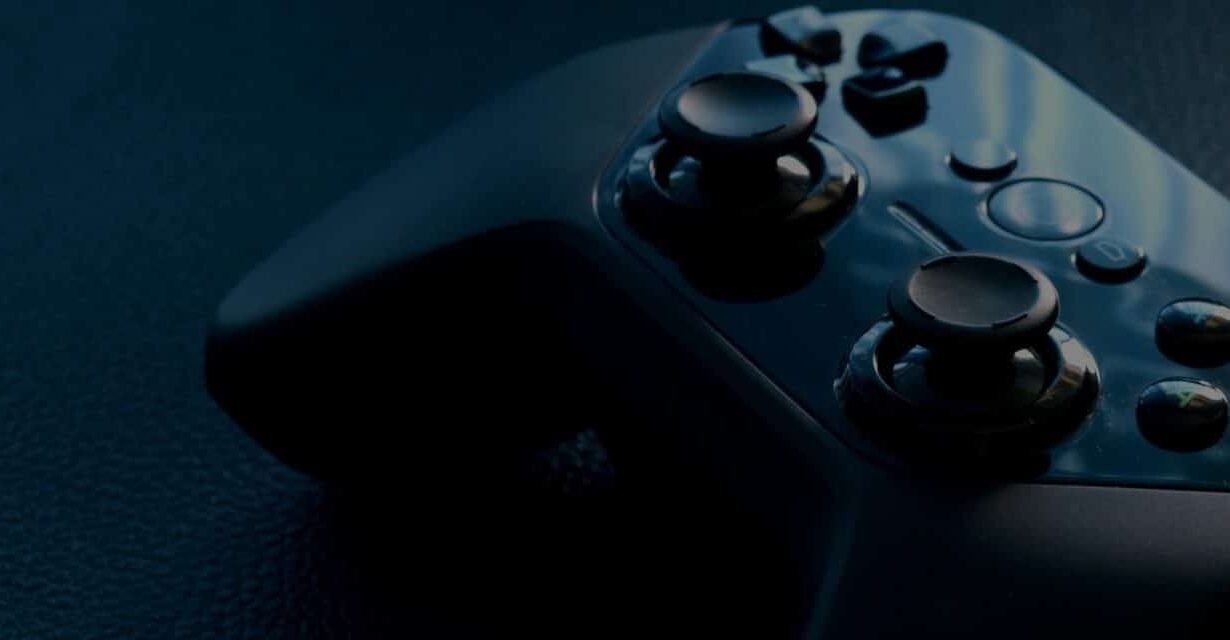 Gros plan d'une manette de jeu noire sur fond sombre