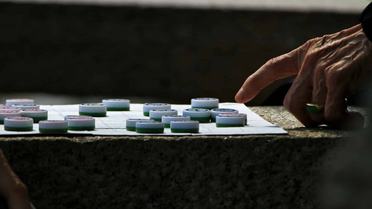 Main déplaçant un pion sur un plateau de jeu