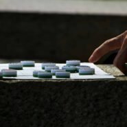 Main déplaçant un pion sur un plateau de jeu