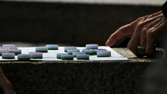 Main déplaçant un pion sur un plateau de jeu