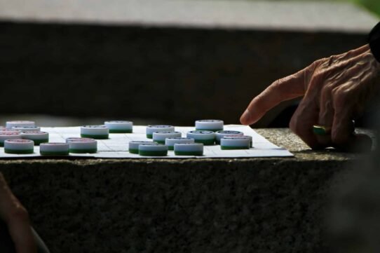 Main déplaçant un pion sur un plateau de jeu