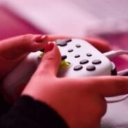 Main tenant une manette de jeu vidéo blanche