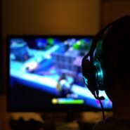 Personne avec un casque jouant à un jeu vidéo sur écran