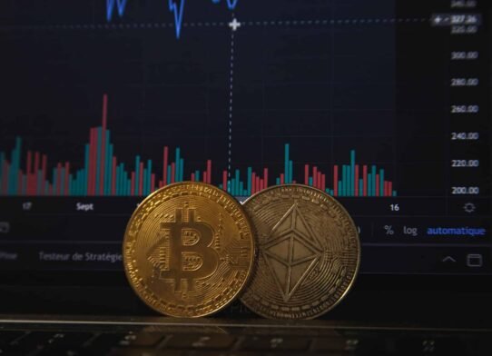 Pièces de Bitcoin et Ethereum devant un graphique boursier