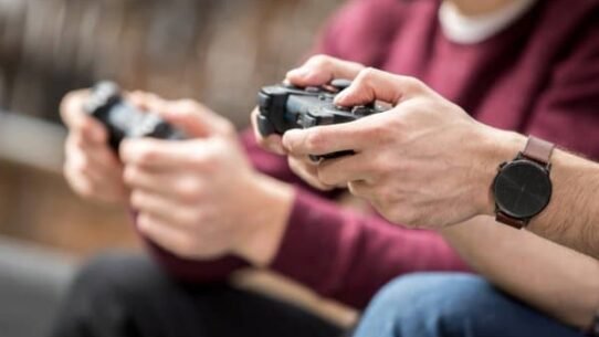 Deux personnes tenant des manettes de jeu vidéo