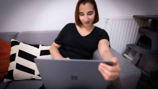 Femme utilisant une tablette sur un canapé