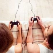 Deux personnes jouant à des jeux vidéo sur un canapé