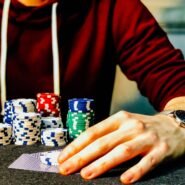 Main d'un joueur de poker avec des jetons empilés