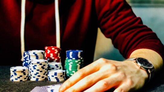 Main d'un joueur de poker avec des jetons empilés