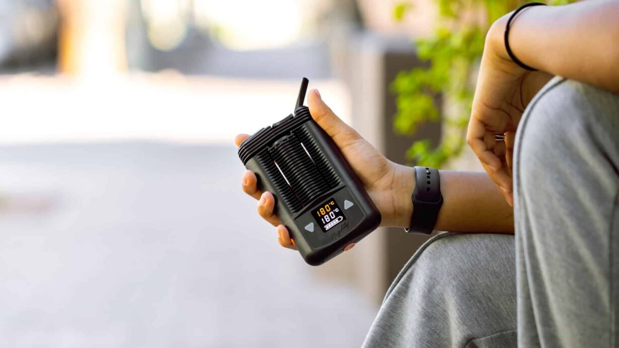 Personne tenant un vaporisateur portable à l'extérieur