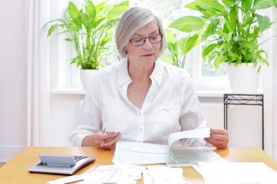 Femme âgée gérant ses finances avec une calculatrice