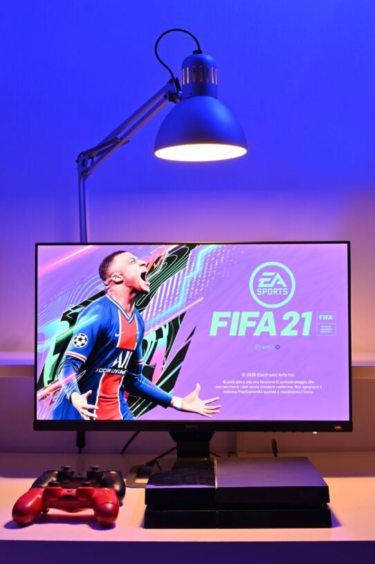 Écran affichant FIFA 21 sous une lampe bleue