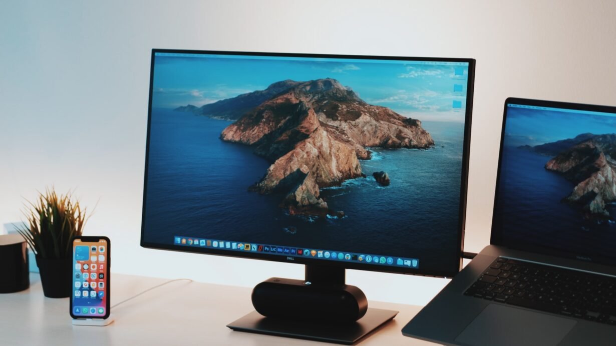 Bureau avec écran Apple, ordinateur portable et smartphone