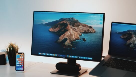 Bureau avec écran Apple, ordinateur portable et smartphone