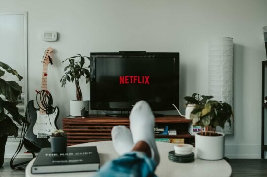 Personne détendue devant une télévision affichant Netflix dans un salon