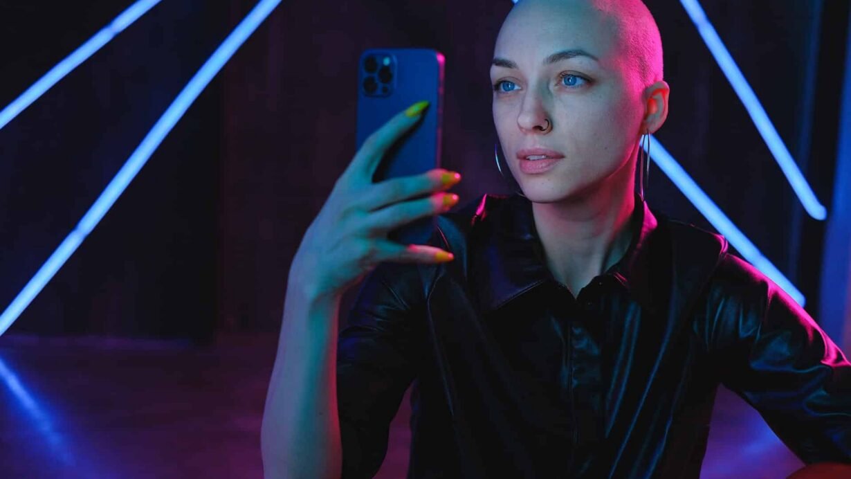 Femme au crâne rasé prenant un selfie avec son smartphone