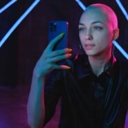 Femme au crâne rasé prenant un selfie avec son smartphone