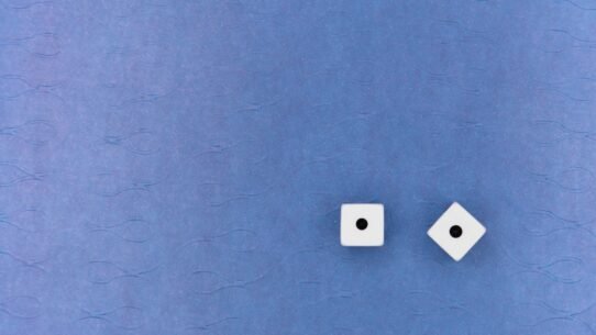 Deux dés blancs avec un point sur fond bleu texturé