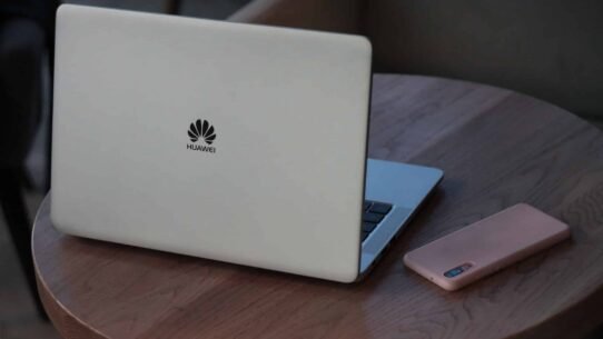 Ordinateur portable Huawei et smartphone sur une table en bois