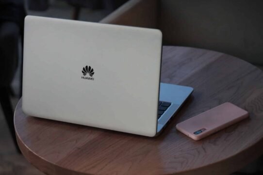 Ordinateur portable Huawei et smartphone sur une table en bois